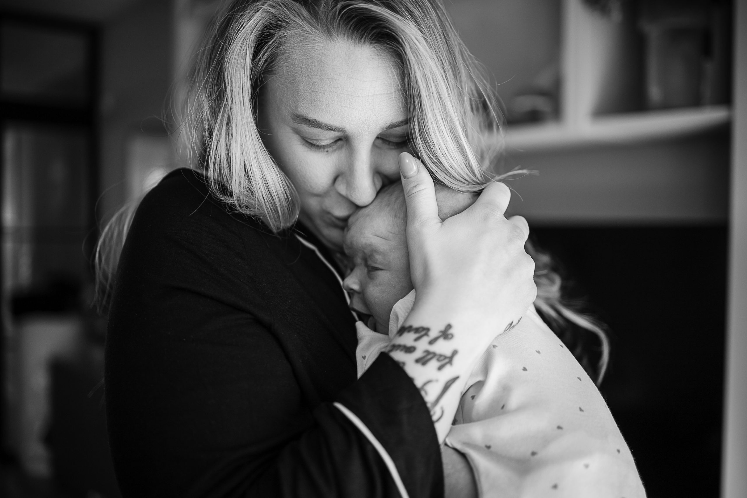 Mamma håller om nyfött barn i famnen.