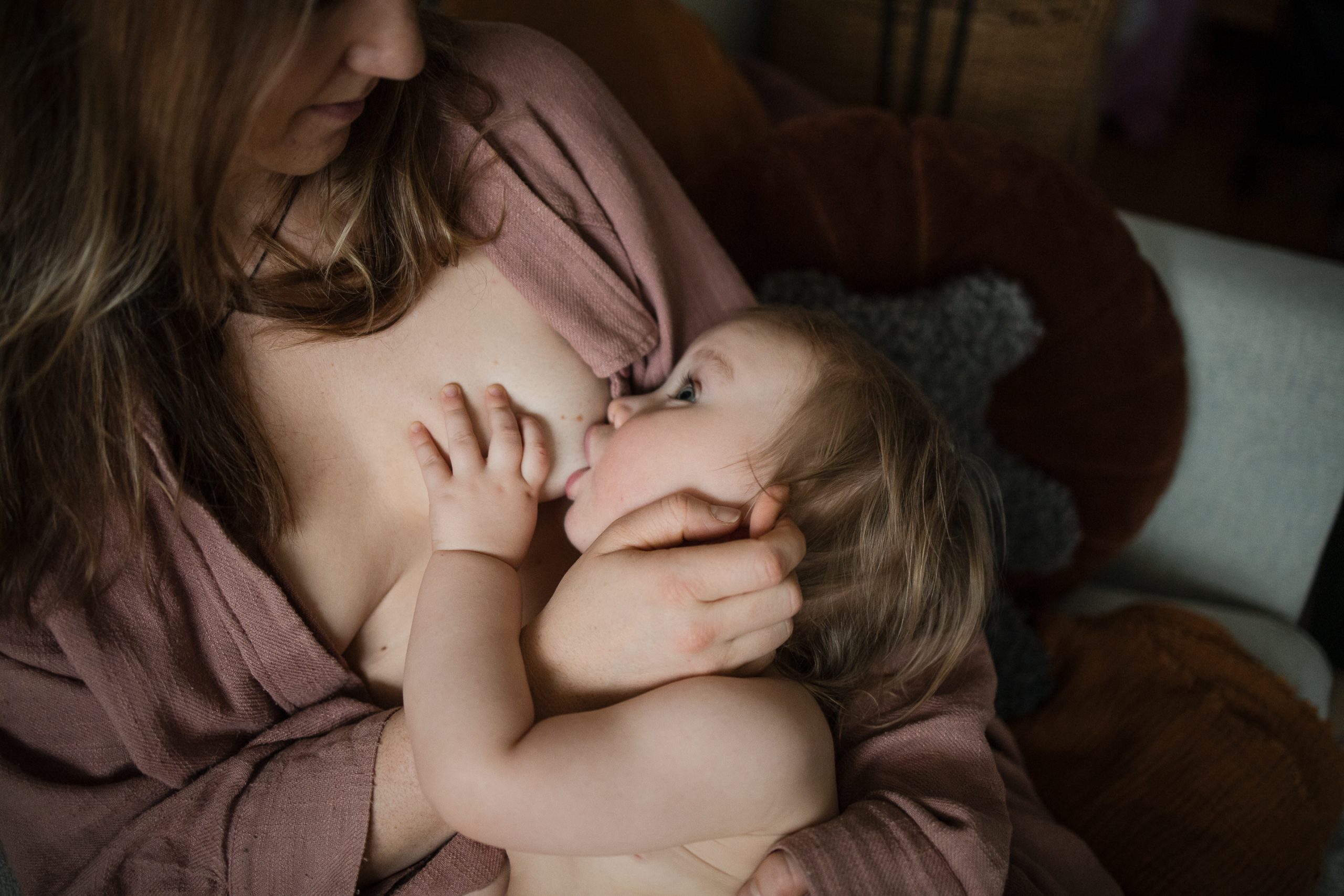 Barn som ammar och tittar upp på sin mamma.
